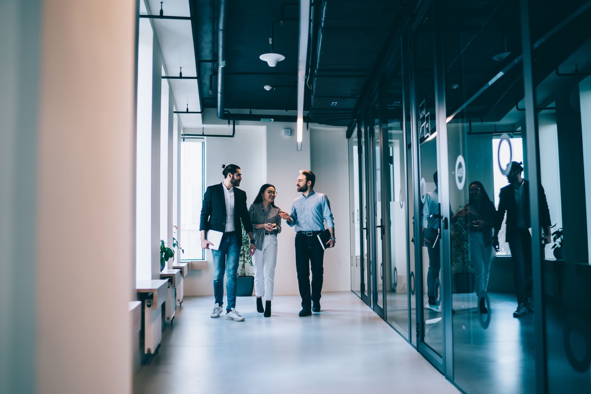 Team im Austausch auf dem Weg durch ein modernes Büro